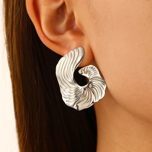 Close-up of model wearing large irregular textured fan-shaped silver alloy earrings