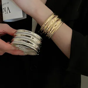 Irregular chunky gold and silver wide bangles with wavy texture and mirror finish