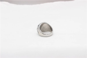 Detail of cross engraving on silver stainless steel ring with polished metallic finish