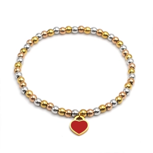 Macro detail of tricolor beads bracelet featuring a vibrant red enamel heart charm