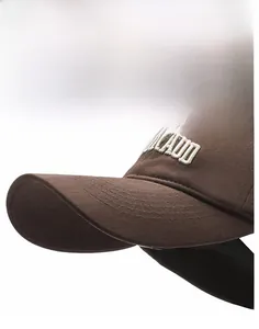 Detailed close-up of coffee brown baseball cap with white 3D embroidery and cotton texture