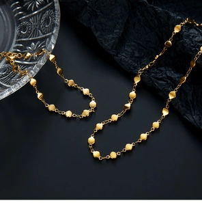 Detailed macro view of 18K gold plated stainless steel disc chain necklace on crystal glass