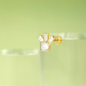 Macro shot of gold s925 silver ear stud with crown shaped cubic zirconia stones