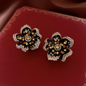 Dettaglio di orecchini vintage a fiore in smalto con cristalli ambra in cofanetto