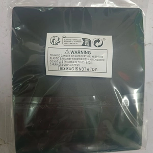 Flat black jewelry display pad accessory in transparent packaging with safety labels
