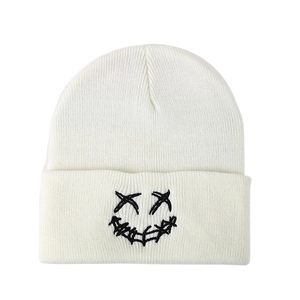 Winter white knit beanie featuring creative black embroidered smiling face for men and women