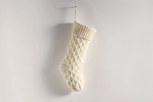 Detailansicht weißer gestrickter Weihnachtsstrumpf mit Rautenmuster und Rippstrickbund