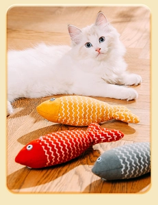 Detailansicht von drei bunten Katzenminze-Fischspielzeugen mit einer weißen Katze