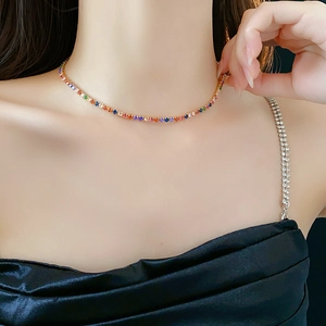 Detail of colorful tennis choker necklace with gold plating shown on female model