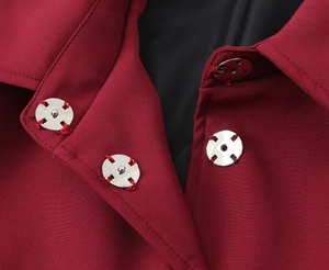 Close-up of silver metal snap button on red blazer with high-quality black lining