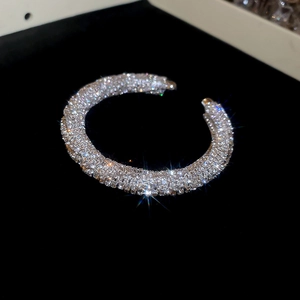 Macro shot of silver textured open bracelet with sparkling pavé crystals on velvet