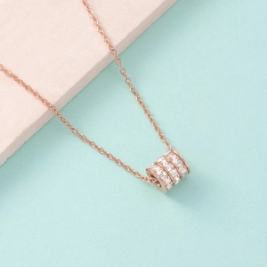 Detailed close-up of rose gold cylinder pendant with three rows of sparkling zircons