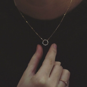 Detail view of S925 sterling silver 14k gold necklace with paved zircon circle pendant