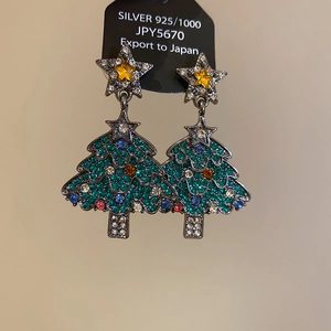 Détail de boucles d'oreilles sapin de Noël en argent s925 avec strass colorés et étoile