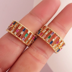 Gold-plated hollow ring featuring colorful baguette-cut zircons worn by a model
