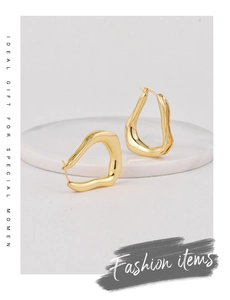 Detailed shot of irregular gold earrings on marble display for special gift moments