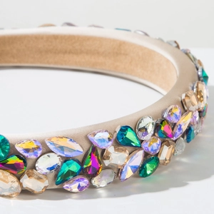 Gros plan de strass colorés sur un serre-tête rembourré en satin couleur champagne