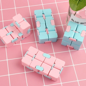 Pink and blue Infinity Cube fidget toy showing various folding and stress-relief shapes