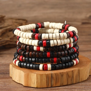 Detailed close-up of multilayered wooden beaded bracelets on a natural wood base