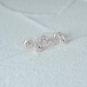 Macro detail of S925 sterling silver knotted stud earrings with purity stamp