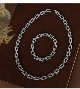 Detail view of silver industrial style chain necklace and bracelet set on velvet