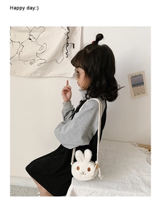 Detail of cream plush bunny crossbody bag on child model with soft sherpa texture