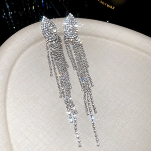 Macro shot of silver tassel earrings with sparkling rhinestones and jellyfish design