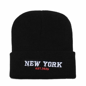 Close-up of white New York embroidery and red Est. 1625 text on a black knit beanie
