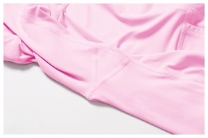 Macro detail of high-waist yoga leggings showing flatlock seams and side pocket in pink