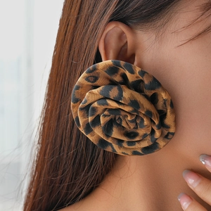 Retro oversized leopard print fabric flower earrings worn by a model in a side view