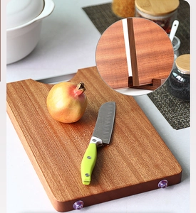 Macro detail of natural ebony wood grain and anti-slip feet on a thick kitchen cutting board