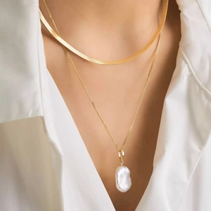 Double-layered gold snake chain and pearl necklace with a white baroque pearl pendant