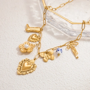 Détail du collier plaqué or 18 carats avec divers pendentifs cœur, papillon et perle