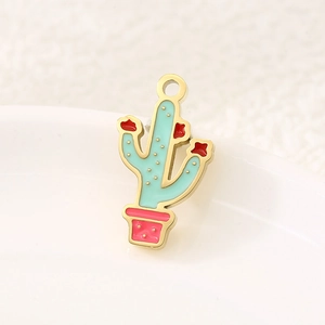 Detailed macro view of a green enamel cactus charm with a red flower on a white plate