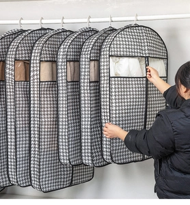 Detail of houndstooth garment bag featuring a transparent window and smooth side zipper