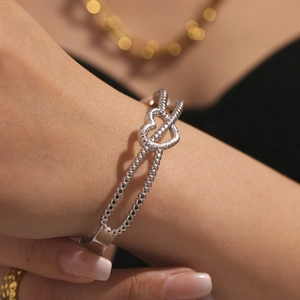 Bracelet à billes en argent poli avec cœurs entrelacés sur poignet féminin élégant