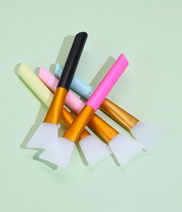 Flat silicone face mask brushes with colorful handles and gold ferrules for skincare