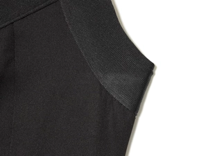 Close-up of black bodycon dress showing elastic fabric texture and stitching details