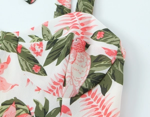 Détail du décolleté en cœur et de l'imprimé floral tropical sur une robe d'été blanche