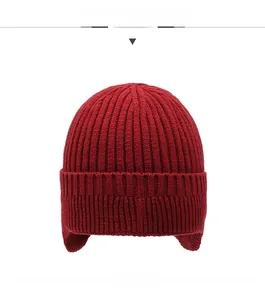 Detailed texture of dark red ribbed knit hat with earflaps for winter protection