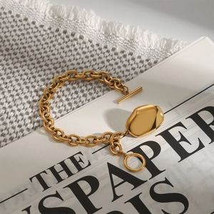 Detail of 18k gold stainless steel chain bracelet with toggle clasp and oval pendant