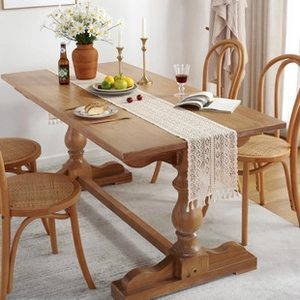 Close-up of beige hollow-out tassel table runner on a wooden dining table