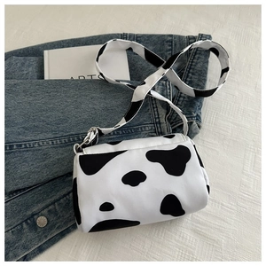 Detail of cow print crossbody bag showing animal pattern texture on denim fabric