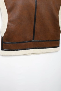 Vue détaillée du gilet en daim marron avec garniture en cuir noir et doublure en polaire