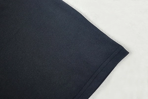 Gros plan sur le tissu en maille bleu foncé montrant les détails de couture double aiguille