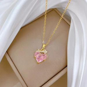 Macro detail of a pink heart-shaped crystal pendant with a gold crown and O-chain