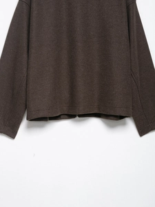 Détail de la texture en laine marron foncé et de la fermeture éclair métallique sur la veste