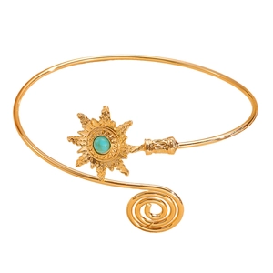 Detailed close-up of a gold boho arm cuff featuring sunburst turquoise and spiral design