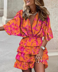 Detail of deep V-neckline and tropical floral print on a layered ruffle orange dress