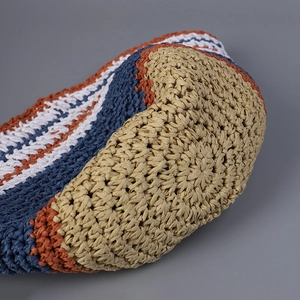 Close-up of a striped handmade straw bucket hat showing woven texture and color details